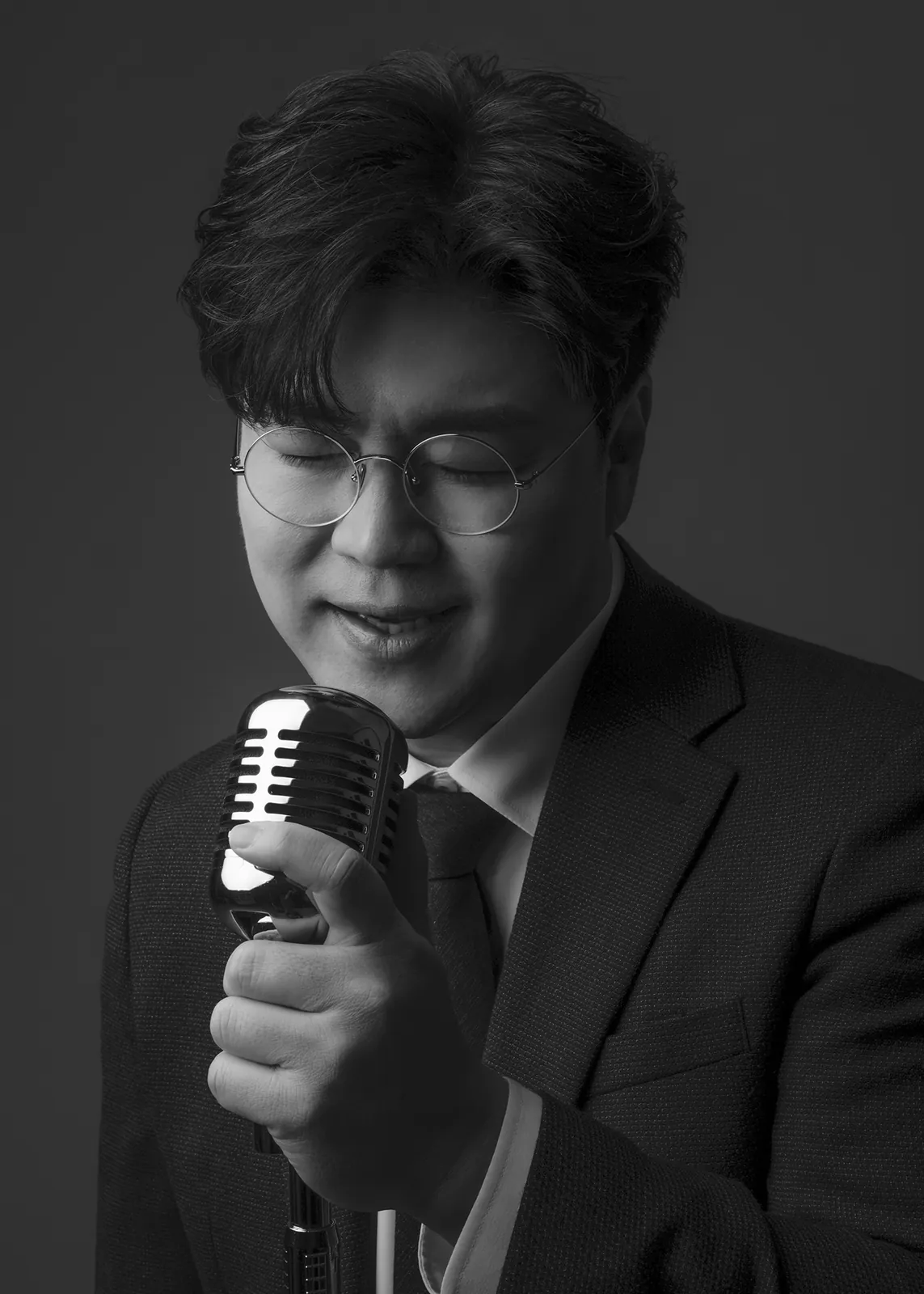 마이크를 가까이 잡고 눈을 감은 채 부르는 박구윤
