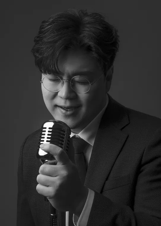 마이크를 가까이 잡고 눈을 감은 채 부르는 박구윤