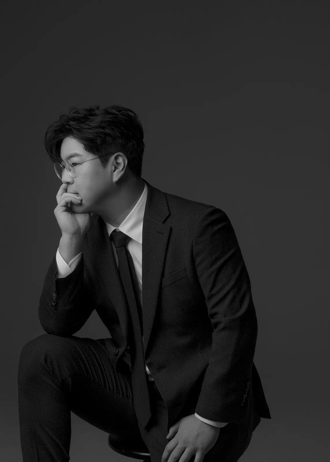 의자에 앉아 턱을 괸 옆모습의 박구윤